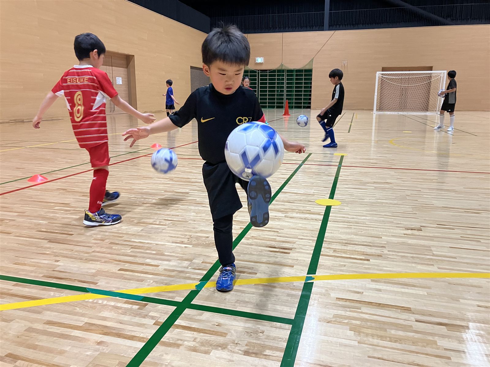リフティングに挑戦する園児・低学年の生徒
